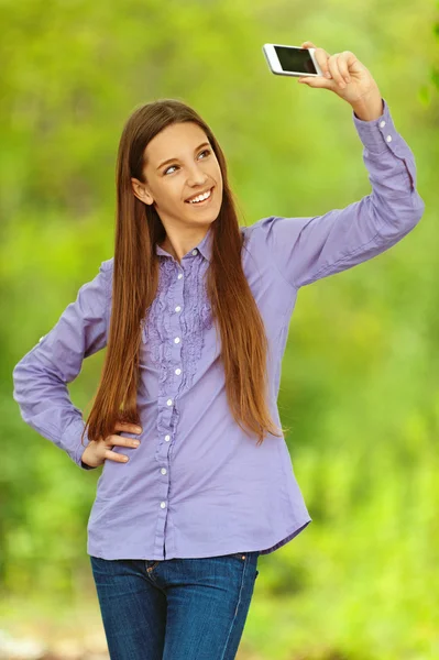 Smiling teenage girl photographing themselves Royalty Free Stock Photos