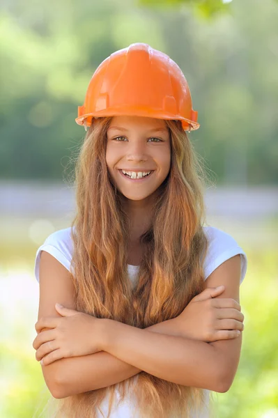 Hermosa adolescente en un casco naranja — Foto de Stock