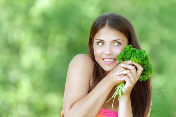 Smiling young woman with bunch of parsley — Stock Photo, Image