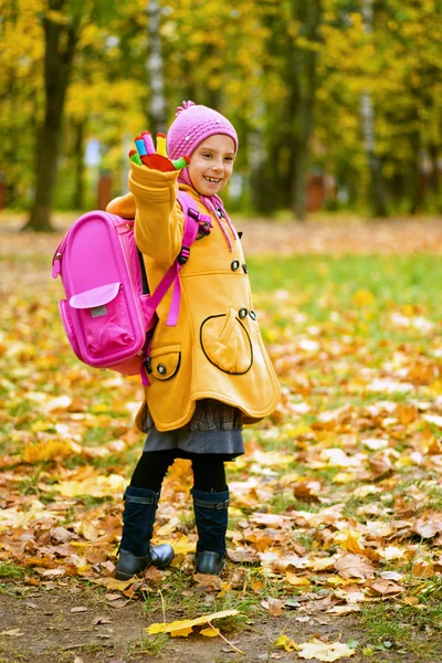 Menina bonita em casaco amarelo e mochila rosa — Fotografia de Stock