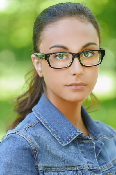 Donkerharige jonge vrouw in denim jasje — Stockfoto