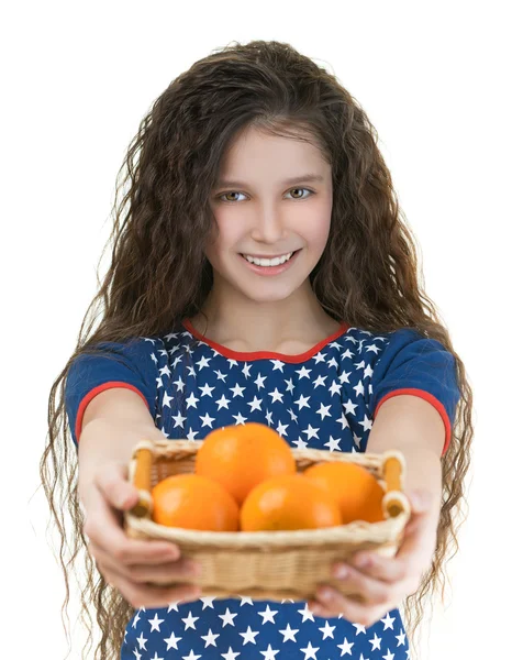 Glimlachend schoolmeisje houdt mand van sinaasappelen — Stockfoto