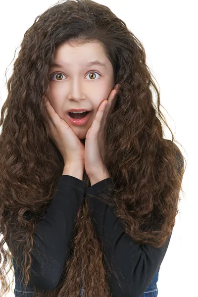 Verrast schoolmeisje met donkere krullend haar Stockfoto