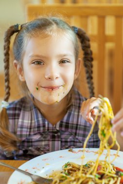 little girl with stained face eating pasta clipart