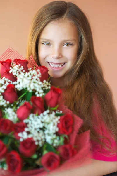 Lächelndes kleines Mädchen mit Rosenstrauß — Stockfoto