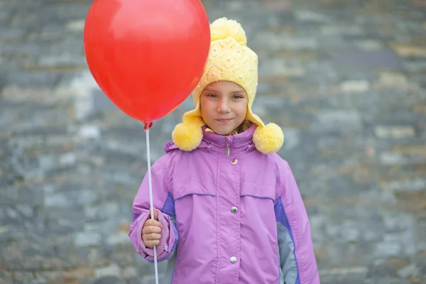 Leende liten flicka med röd ballong — Stockfoto