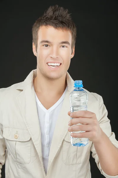 Jovem segurando garrafa de água — Fotografia de Stock