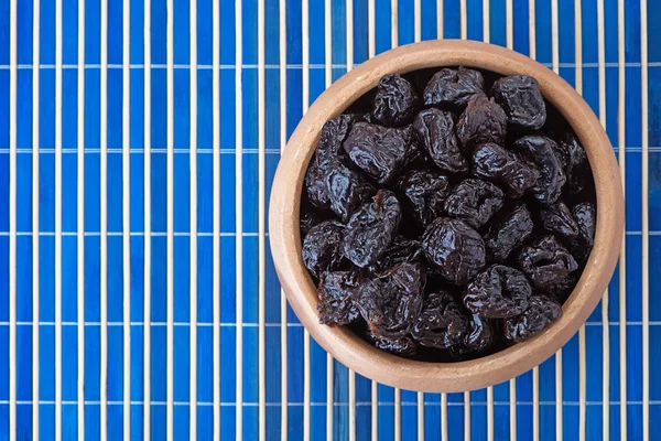 Dried prunes in wooden bowl — Stock Photo, Image