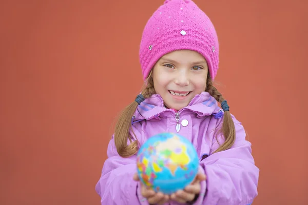 Menina alegre na jaqueta rosa segurando globo — Fotografia de Stock