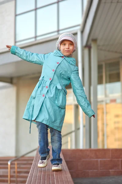 Bambina in cappotto blu che cammina sul marciapiede — Foto Stock