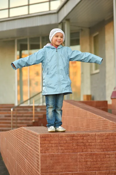 Fille souriante debout sur le trottoir de pierre — Photo