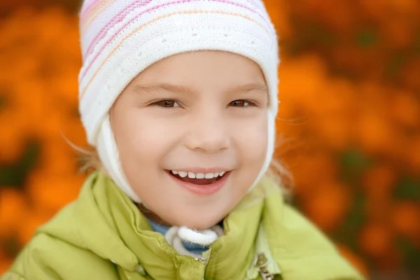 Smiling little girl in green jacket — Stock Photo, Image