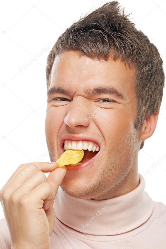 portrait of young man eating chips