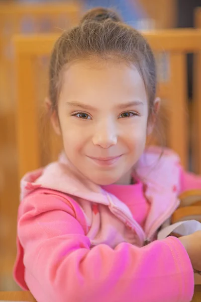 Vorschulmädchen sitzt am Tisch — Stockfoto