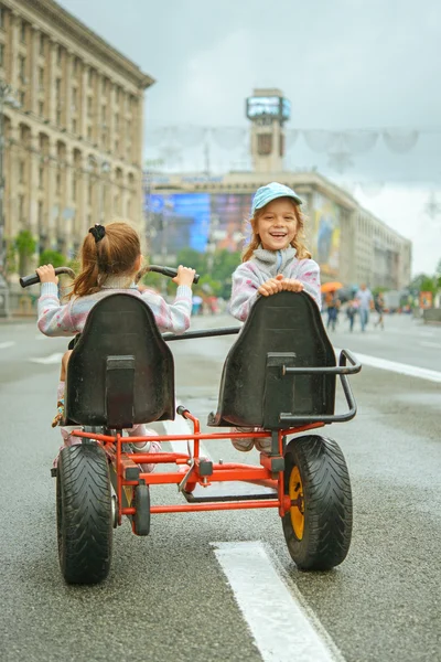 Due bambine in sella ciclo giocattolo — Foto Stock