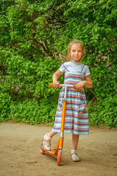 Petite fille est en scooter — Photo