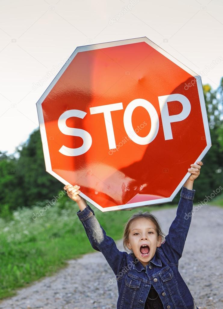 little girl holding a red sign 