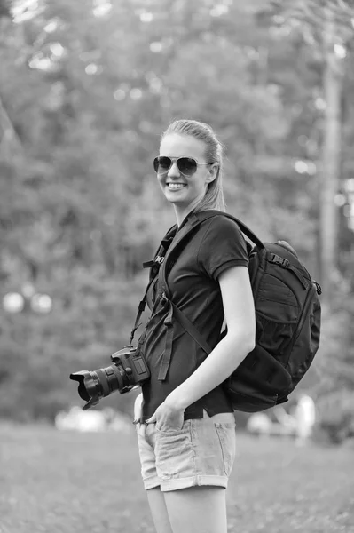 Sorridente jovem mulher fotografias na câmera — Fotografia de Stock