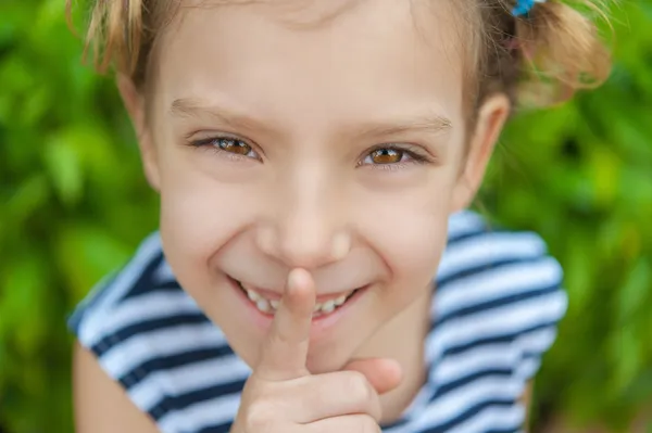 Menina alegre põe o dedo indicador a lábios — Fotografia de Stock