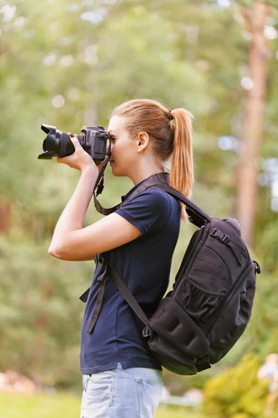 Улыбающаяся молодая женщина фотографирует на камеру — стоковое фото