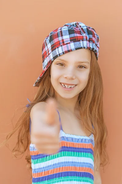 Smiling girl in dress raises thumbs-up — Stock Photo, Image