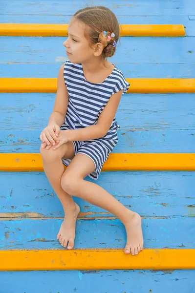 Ahşap köprü üzerinde oturan neşeli kız — Stok fotoğraf