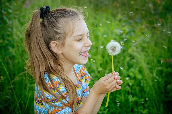 Kis lány fúj ondandelion — Stock Fotó