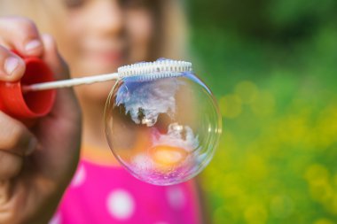 little girl creates bubbles clipart