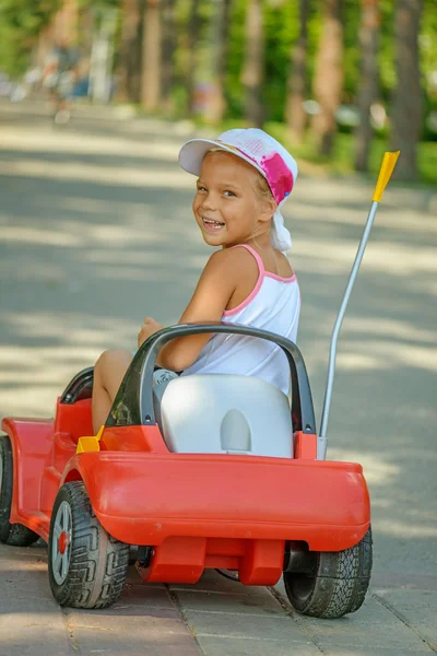 Kis lány lovaglás játék-autó — Stock Fotó