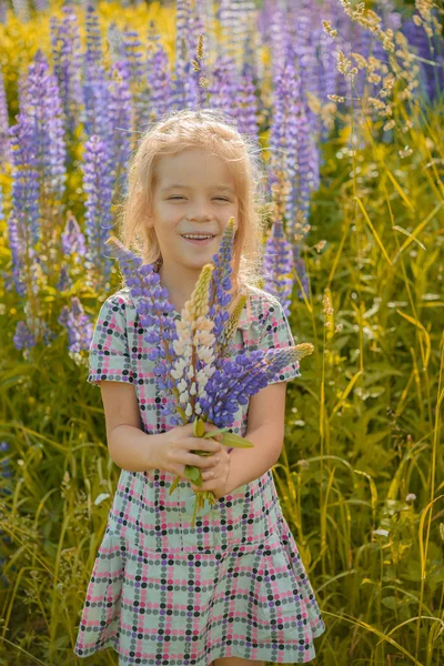 Lilla tjej går på blommande äng — Stockfoto