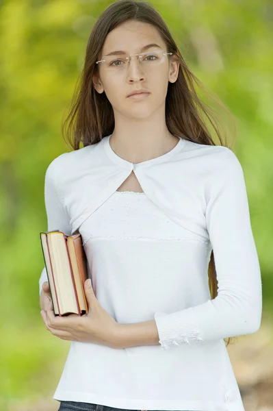 Adolescente vestida de branco com livros — Fotografia de Stock