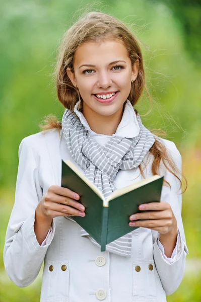 Vacker kvinna läsande grön bok — Stockfoto