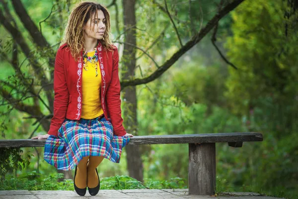 Vrouw met dreadlocks zittend op de Bank — Stockfoto