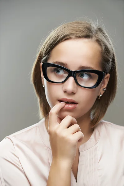 Zamyślony młoda kobieta w okularach — Zdjęcie stockowe