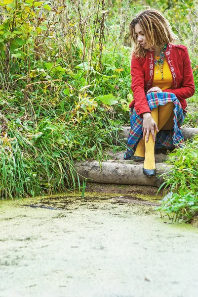 Kvinna med dreadlocks nära kärr — Stockfoto