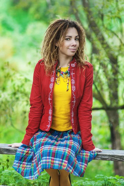 Frau mit Dreadlocks sitzt auf Bank — Stockfoto