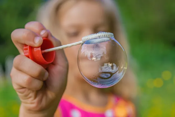 Little girl creates bubbles — Stock Photo, Image