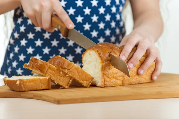 Girl cut bread with knife — Stock Photo, Image