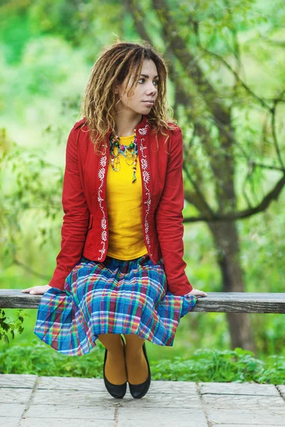 Mulher com dreadlocks sentado no banco — Fotografia de Stock