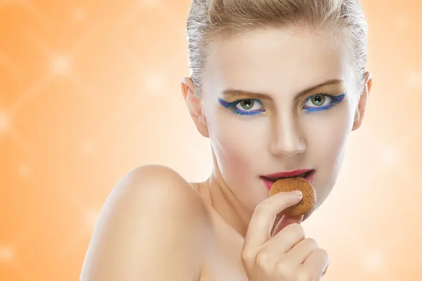 Beautiful young woman with cookie — Stock Photo, Image