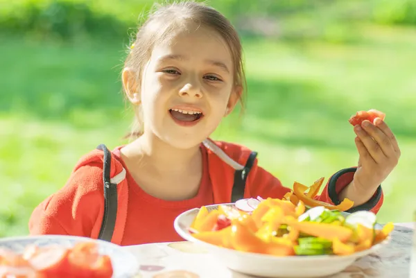 Giovane ragazza mangia verdure — Foto Stock