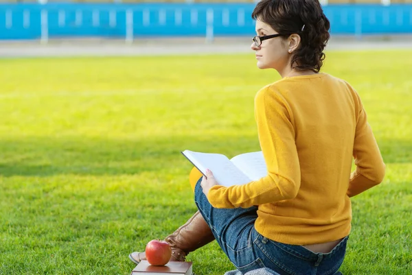 Ragazza legge libro sul prato — Foto Stock