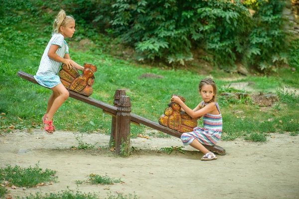 Two sisters ride on swings — Stock Photo, Image