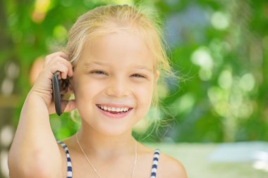 küçük kız cep telefonuyla konuşuyor