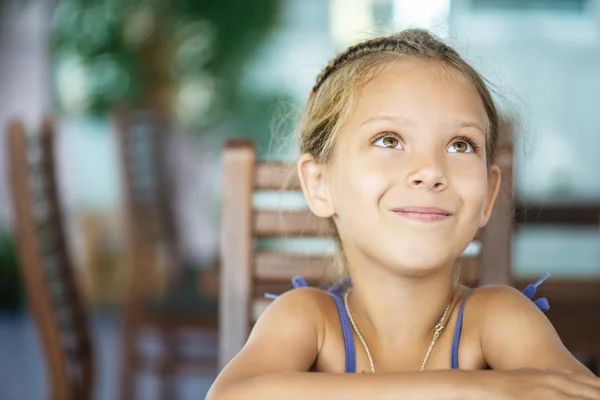 Liten flicka sitter vid bord — Stockfoto