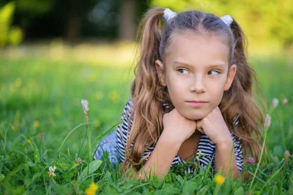 Vacker flicka ligger på grönt gräs — Stockfoto