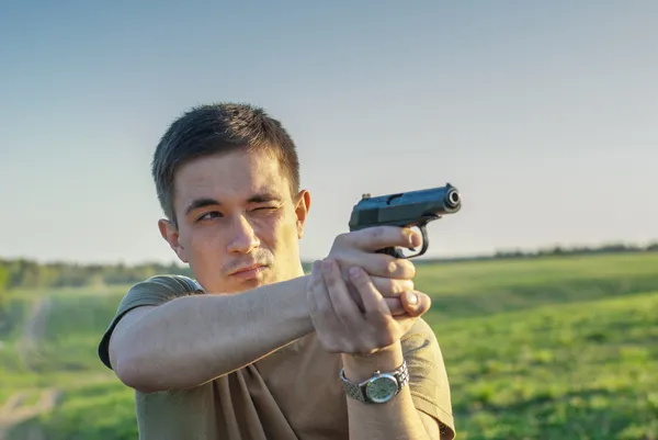 Молодой человек прицелился из пистолета — стоковое фото