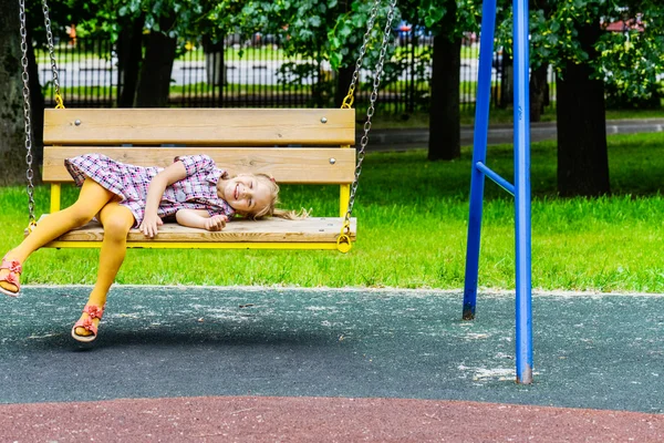 Portrait of a little blond girl on swing — Stock Photo, Image