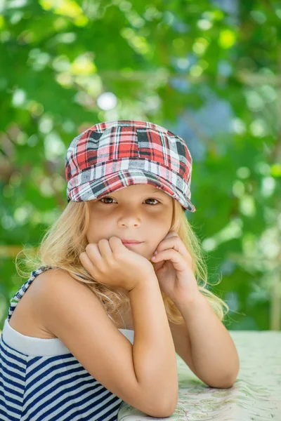 Küçük kız ekoseli şapka konuşuyor — Stok fotoğraf