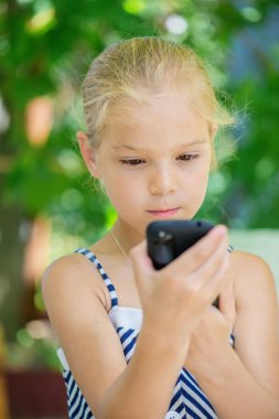 küçük kız cep telefonuyla konuşuyor